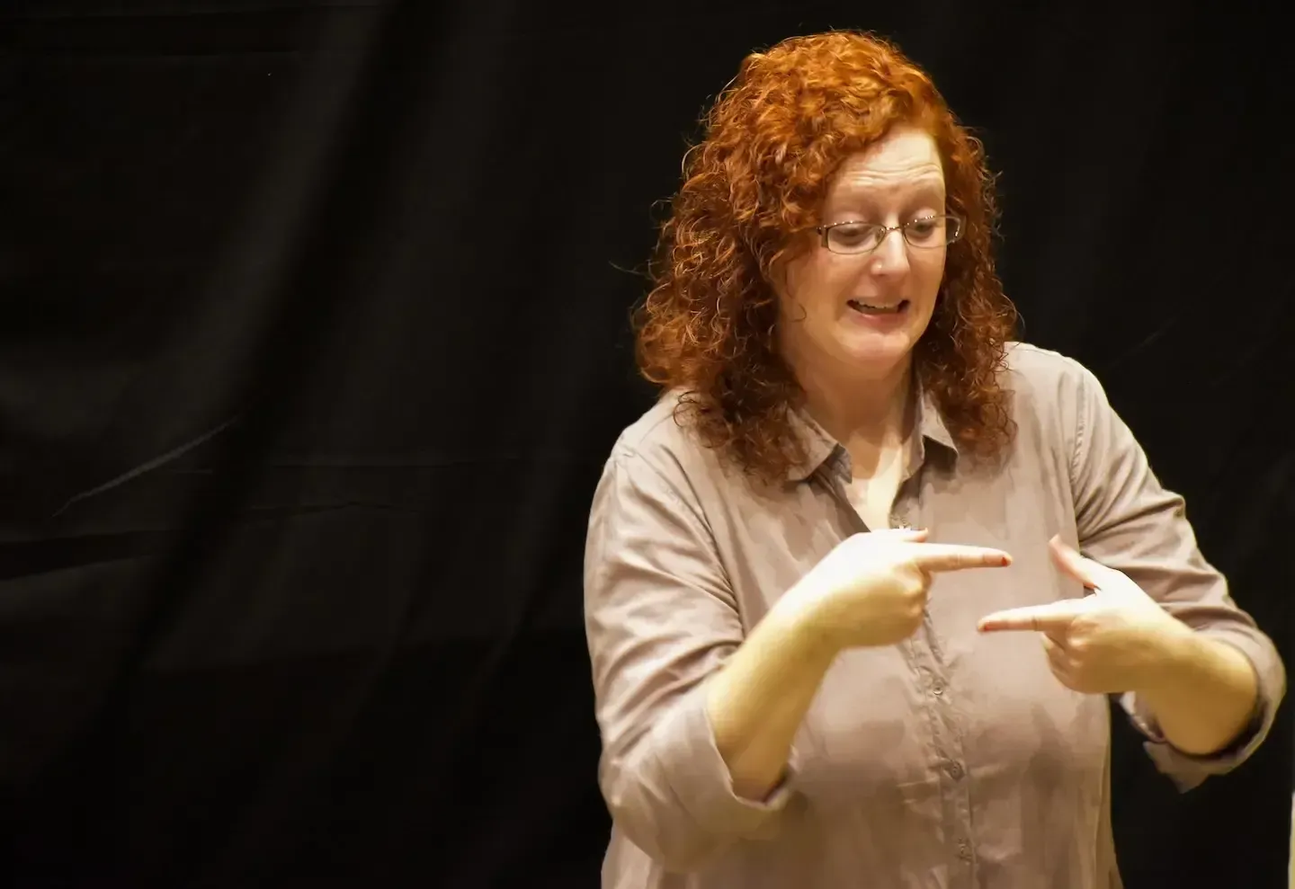 Deaf Ministry leader signing during a Highland gathering